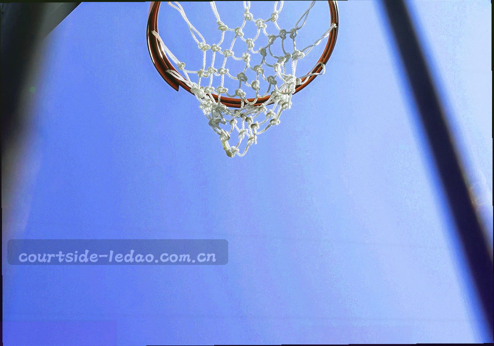 球场边线旁的战术板与球员背影局部，光线偏暗